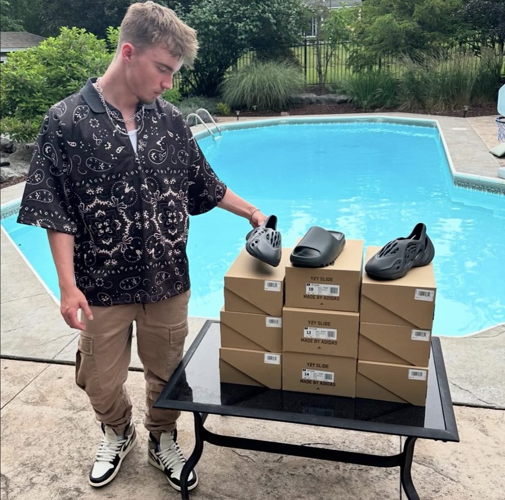 Aiden with a stack of YZY Slides and Foam Runners